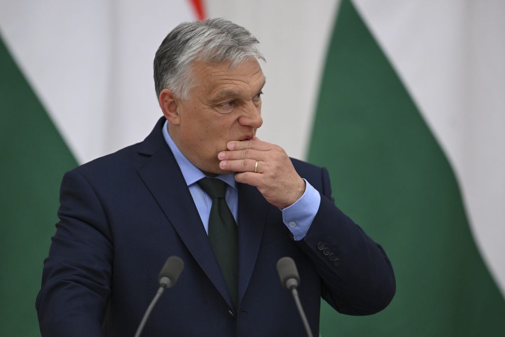 Hungarian Prime Minister Viktor Orban looking worried and about to speak in front of a podium